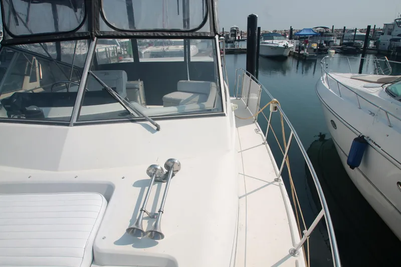 Slide: The Image of 1996 Carver 330 Mariner yacht docked at marina, showcasing deck and cabin area. - 10