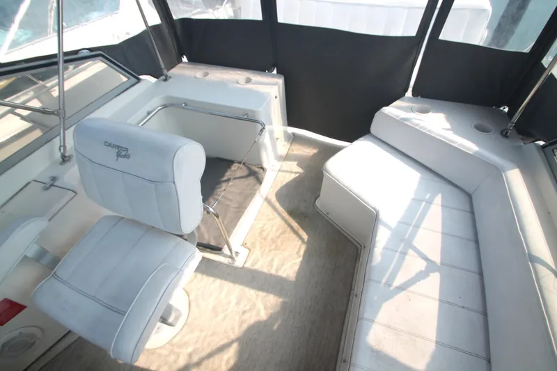 Slide: The Image of Interior of 1996 Carver 330 Mariner boat with white seating and helm chair. - 14