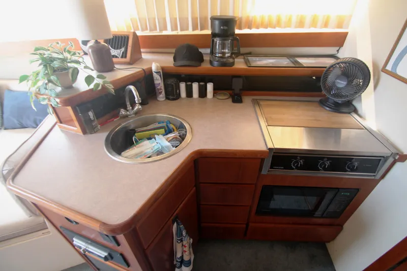 Slide: The Image of 1996 Carver 330 Mariner kitchen with sink, stove, microwave, and countertop appliances. - 3
