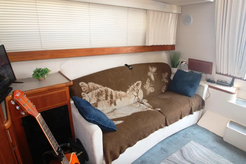 Slide: The Image of Interior of 1996 Carver 330 Mariner with cozy sofa, guitar, and decorative elements. - 36