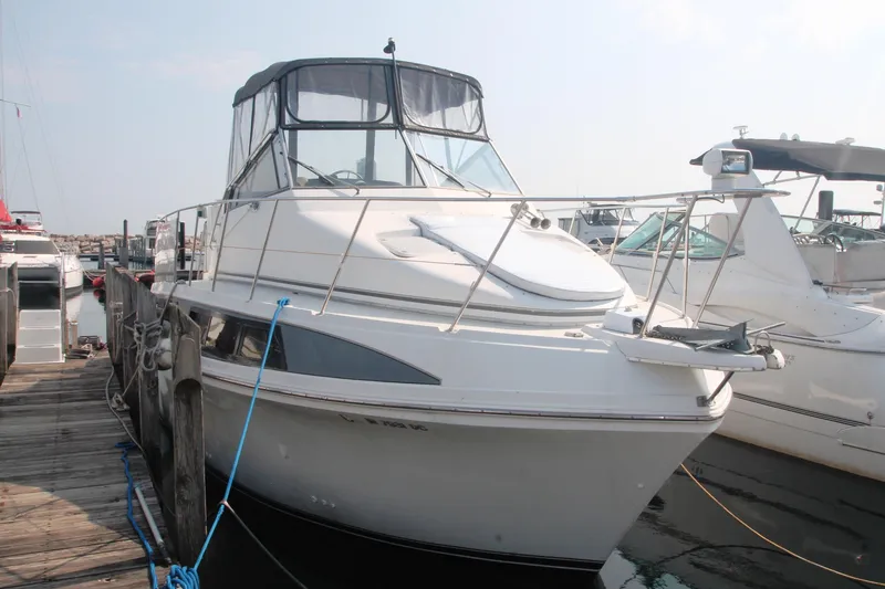 Slide: The Image of 1996 Carver 330 Mariner yacht docked at a marina, featuring sleek design and spacious deck. - 4