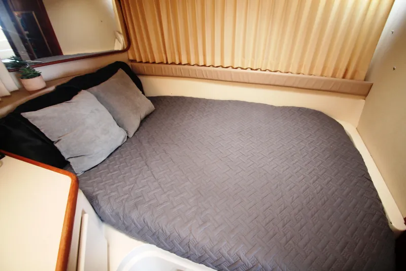 Slide: The Image of Cozy bedroom interior of 1996 Carver 330 Mariner yacht with gray bedding and pillows. - 40