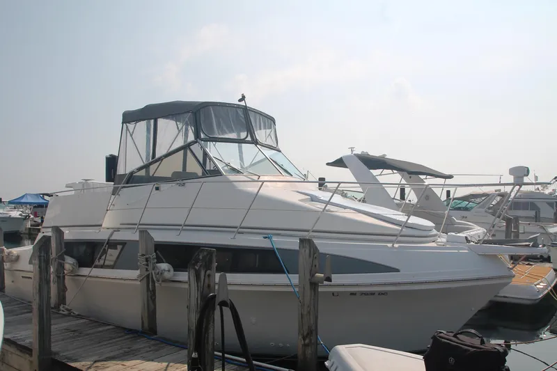 Slide: The Image of 1996 Carver 330 Mariner docked at a marina under a clear sky. - 5