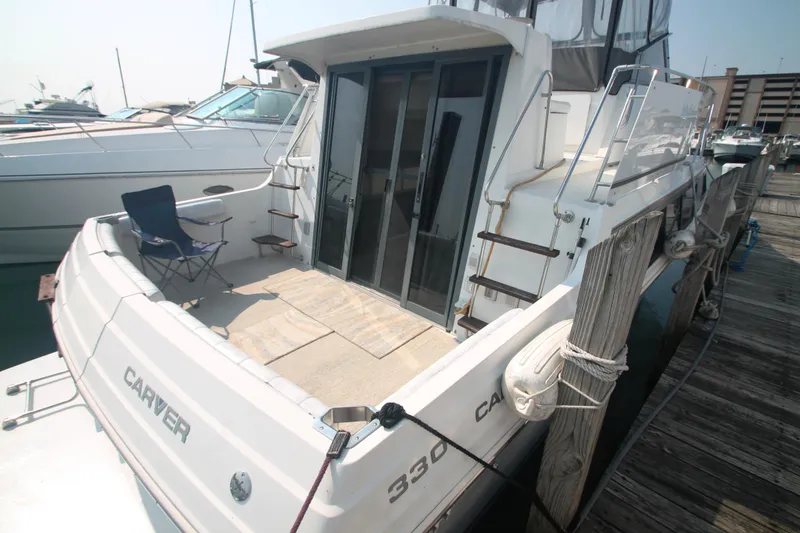 Slide: The Image of 1996 Carver 330 Mariner yacht docked at marina with outdoor seating. - 6