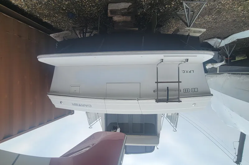 Slide: The Image of Upside-down view of a 1996 Carver 330 Mariner boat on a gravel surface. - 60