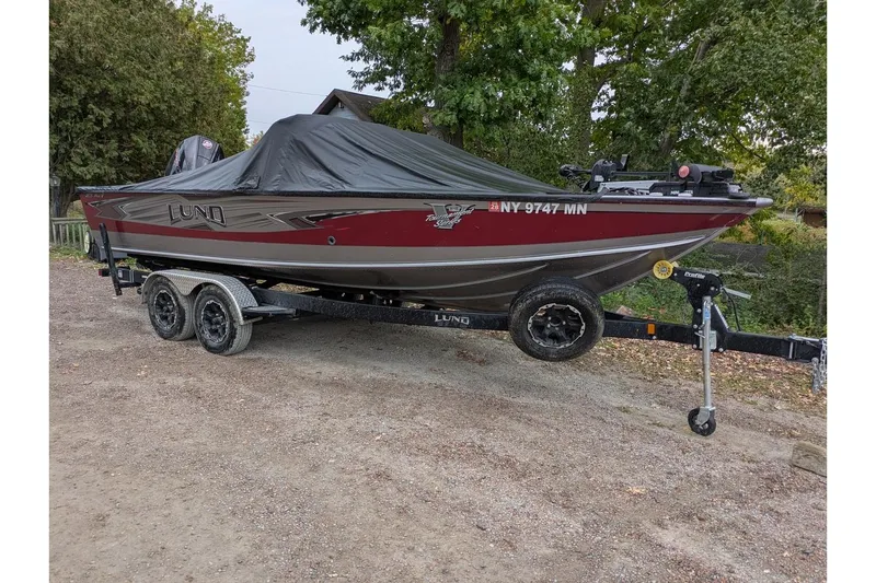 The Image of 2019 Lund 2175 Pro-V boat on trailer, covered, parked outdoors. - 0