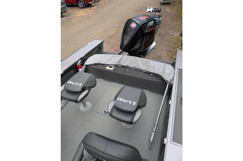 Slide: The Image of 2019 Lund 2175 Pro-V boat interior with seating and outboard motor. - 8