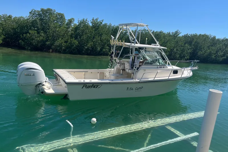 Slide: The Image of 2005 Parker 2510 Modified Vee Walkaround boat on clear water, surrounded by lush greenery. - 3