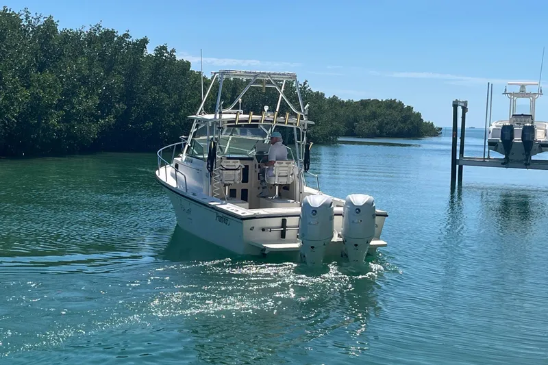 Slide: The Image of 2005 Parker 2510 Modified Vee Walkaround boat cruising in clear waters near mangroves. - 4