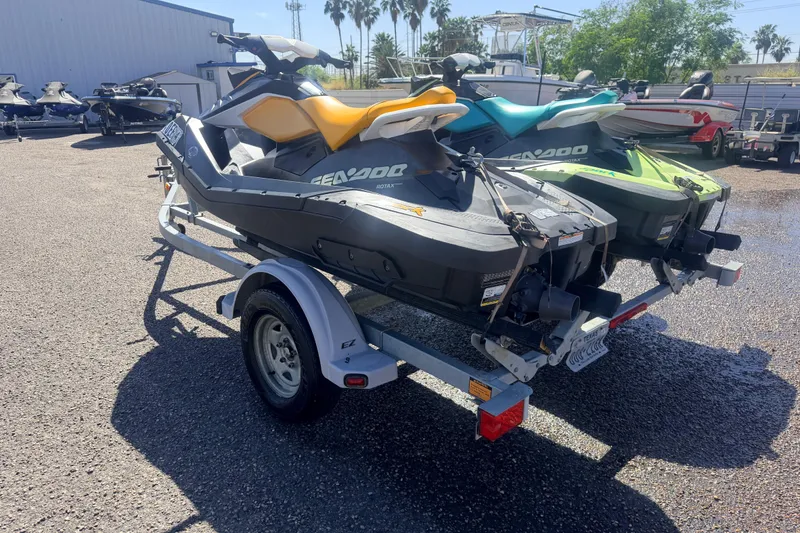 Slide: The Image of 2018 Sea-Doo Spark 2up jet skis on trailer, parked outdoors in sunny setting. - 3