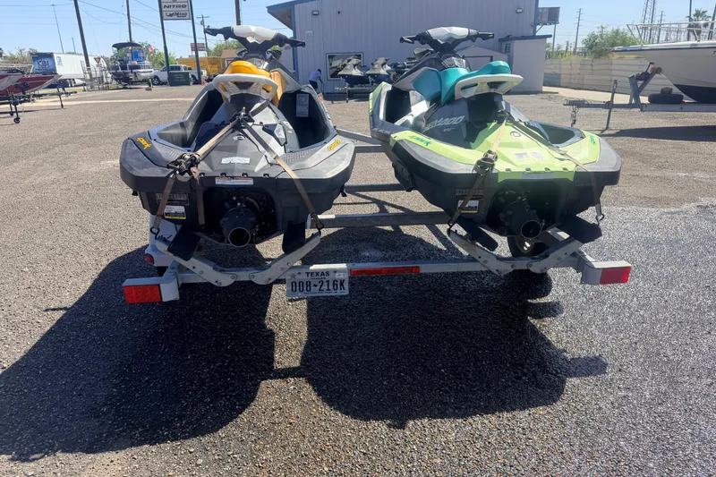 Slide: The Image of Two 2018 Sea-Doo Spark 2up jet skis on a trailer in a parking lot. - 4