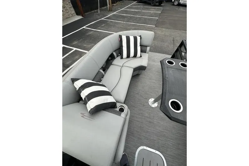 Slide: The Image of Gray seating area on 2022 Bennington 24 LSBA boat with striped cushions and cup holders. - 12
