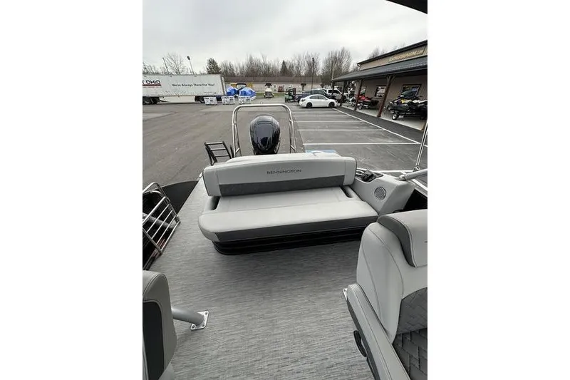 Slide: The Image of 2022 Bennington 24 LSBA pontoon boat with gray seating and outboard motor. - 21