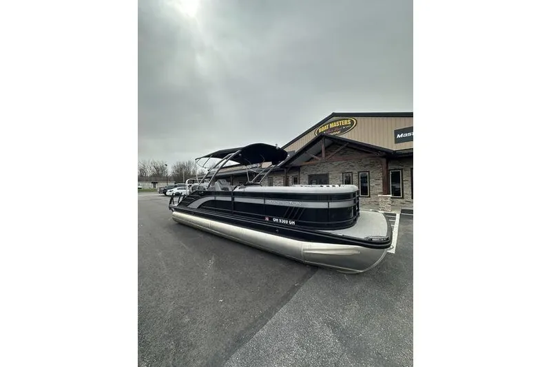 Slide: The Image of 2022 Bennington 24 LSBA pontoon boat parked outside a dealership on a cloudy day. - 3