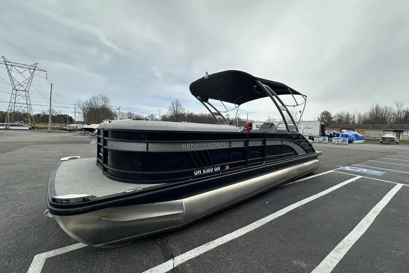Slide: The Image of 2022 Bennington 24 LSBA pontoon boat parked in a lot under cloudy skies. - 5