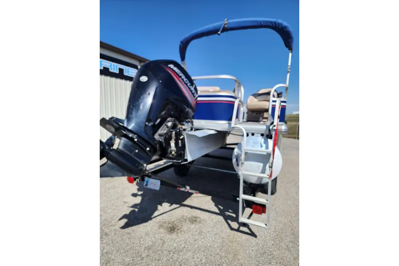 Slide: The Image of 2015 Sun Tracker Fishin' Barge 20 DLX with Mercury outboard motor, parked outdoors. - 2