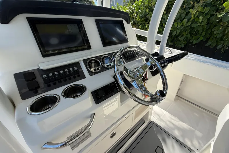 Slide: The Image of 2017 Robalo R242 Center Console helm with dual displays and chrome steering wheel. - 13