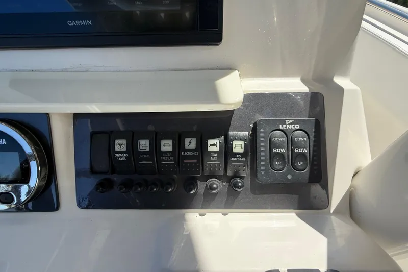 Slide: The Image of Control panel of a 2017 Robalo R242 Center Console boat with switches and Lenco trim tabs. - 14