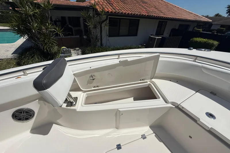 Slide: The Image of 2017 Robalo R242 Center Console boat with open storage compartment and cushioned seating. - 19