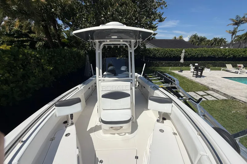 Slide: The Image of 2017 Robalo R242 Center Console boat docked near a poolside patio. - 22