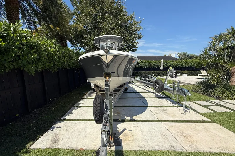 Slide: The Image of 2017 Robalo R242 Center Console boat on trailer, surrounded by lush greenery. - 3