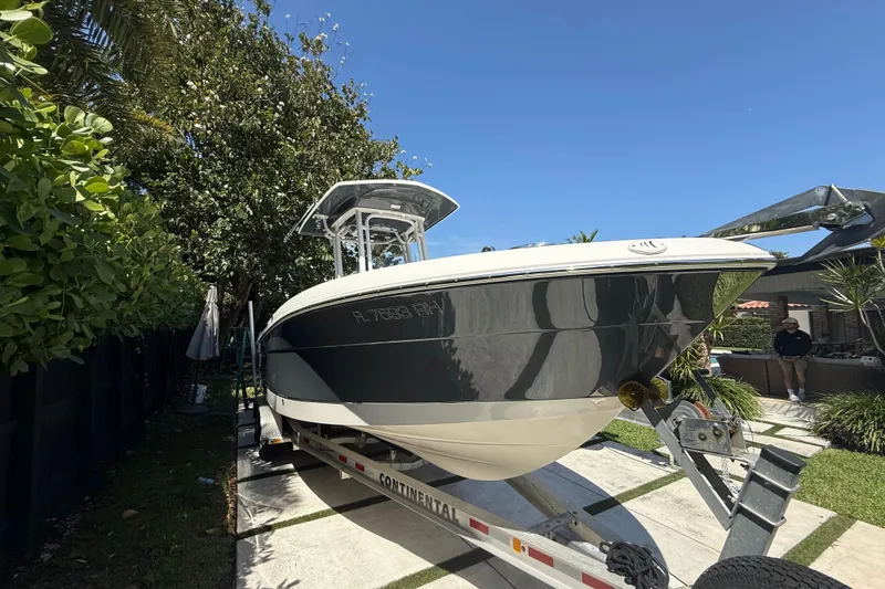 Slide: The Image of 2017 Robalo R242 Center Console boat on trailer, surrounded by lush greenery. - 4