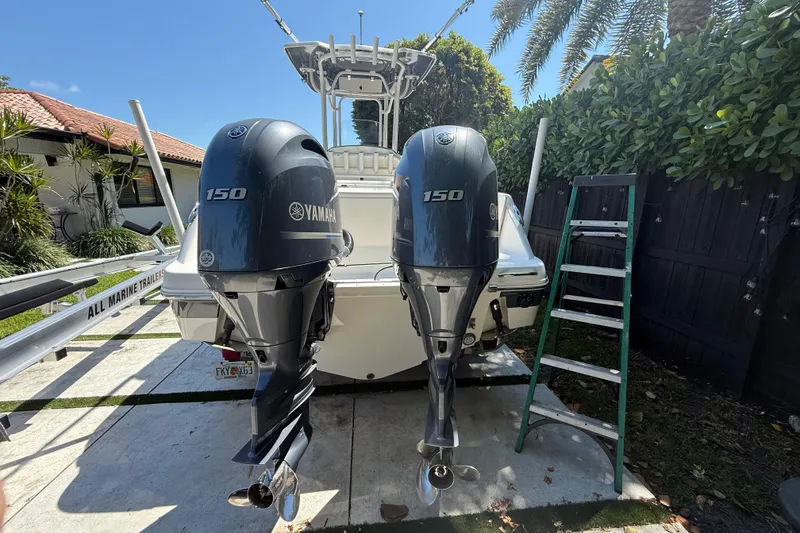 Slide: The Image of 2017 Robalo R242 Center Console with twin Yamaha 150 engines, parked outdoors. - 5