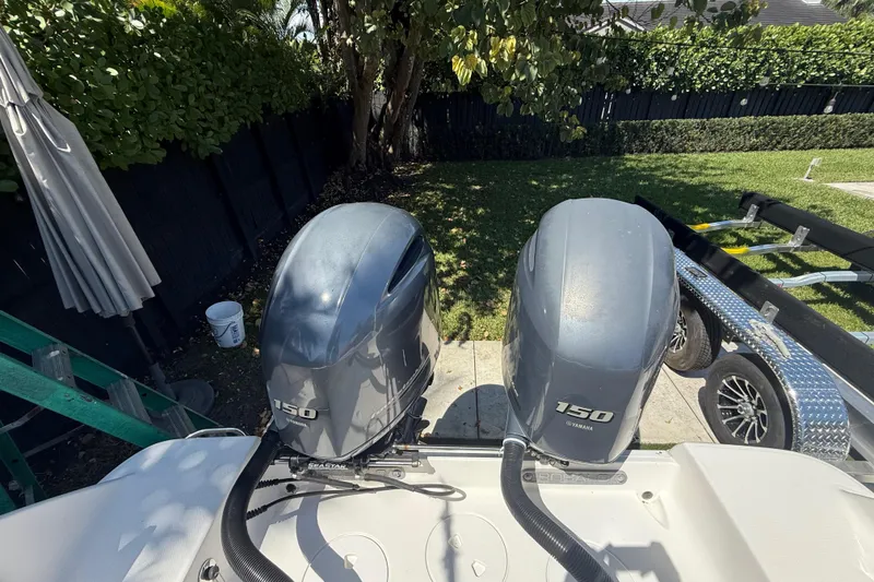 Slide: The Image of 2017 Robalo R242 Center Console with twin Yamaha 150 engines in a backyard setting. - 7