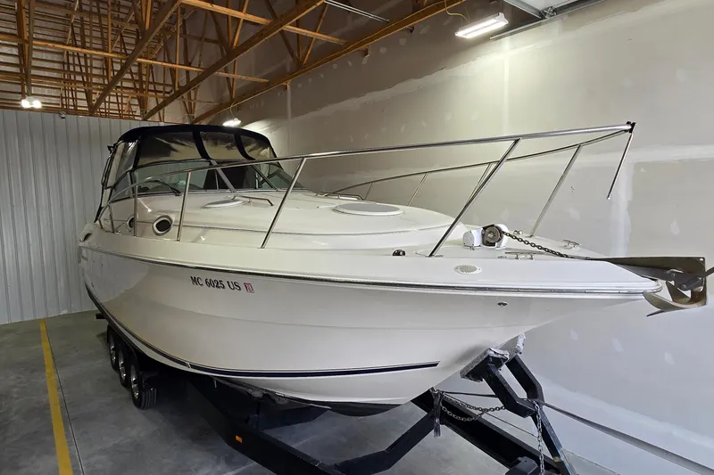 Slide: The Image of 2000 Monetery 302 Express boat in storage, featuring sleek design and white exterior. - 2