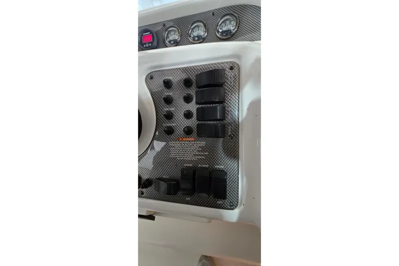 Slide: The Image of Control panel of a 2000 Monetery 302 Express boat with switches and gauges. - 22