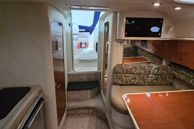 Slide: The Image of Interior of a 2000 Monterey 302 Express boat with seating and wooden cabinetry. - 28