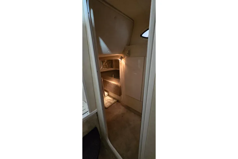 Slide: The Image of Interior cabin of a 2000 Monetery 302 Express boat, featuring cozy lighting. - 32