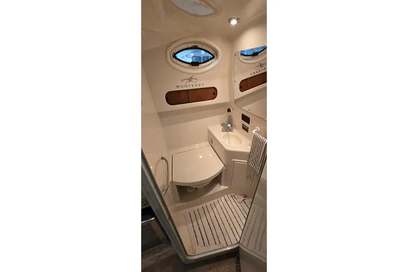 Slide: The Image of Interior of a 2000 Monterey 302 Express boat bathroom with sink and porthole. - 34