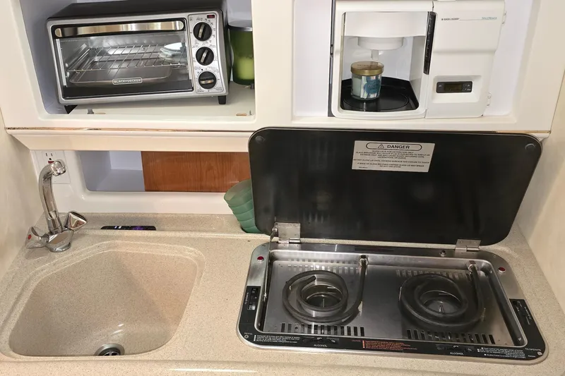 Slide: The Image of Compact kitchen setup in a 2000 Monetery 302 Express boat with stove, sink, and appliances. - 37