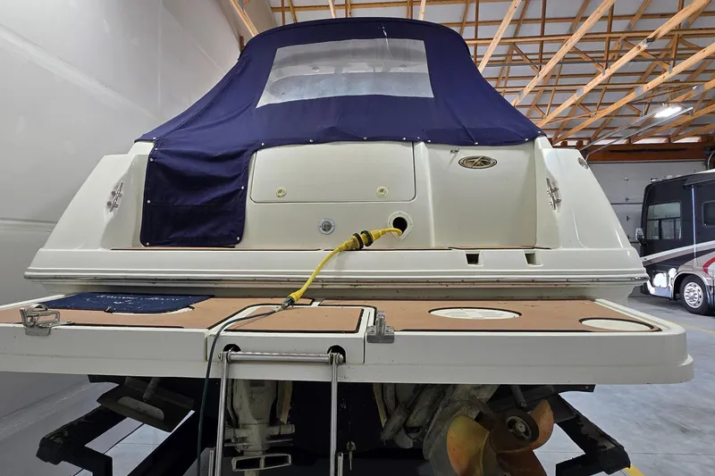 Slide: The Image of Rear view of a 2000 Monetery 302 Express boat in a garage setting. - 5