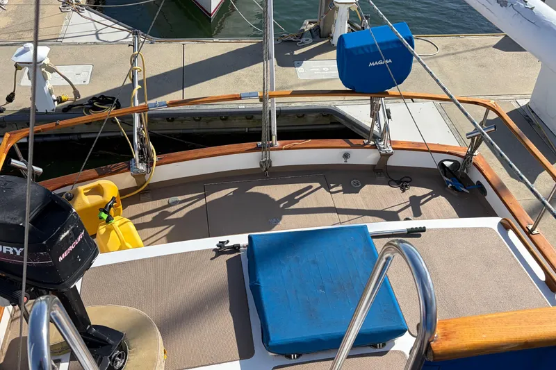 Slide: The Image of 1985 Albin 36 Trawler deck with Mercury engine and blue seating at dock. - 11