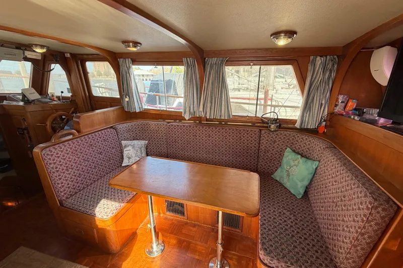 Slide: The Image of Interior of a 1985 Albin 36 Trawler with cozy seating and wooden table. - 17