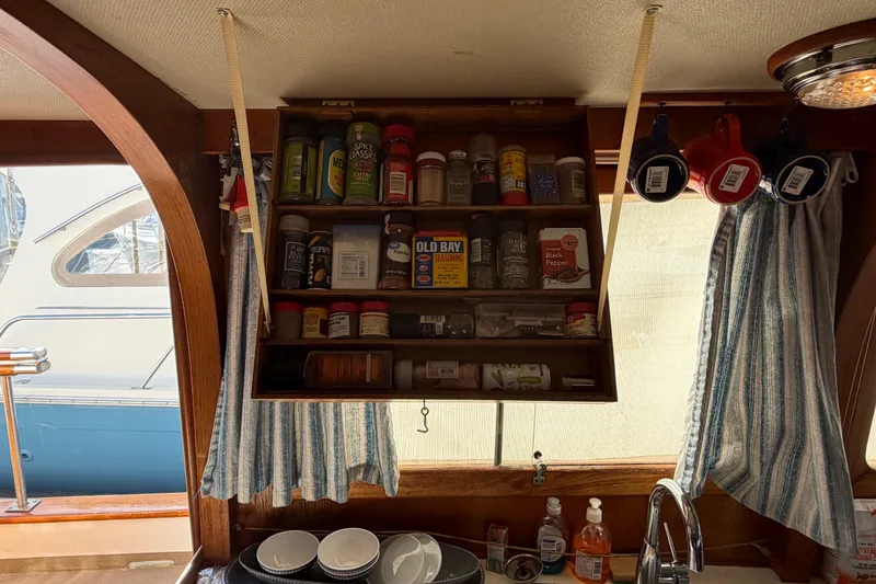 Slide: The Image of Interior of 1985 Albin 36 Trawler with spice rack and hanging mugs in kitchen area. - 22