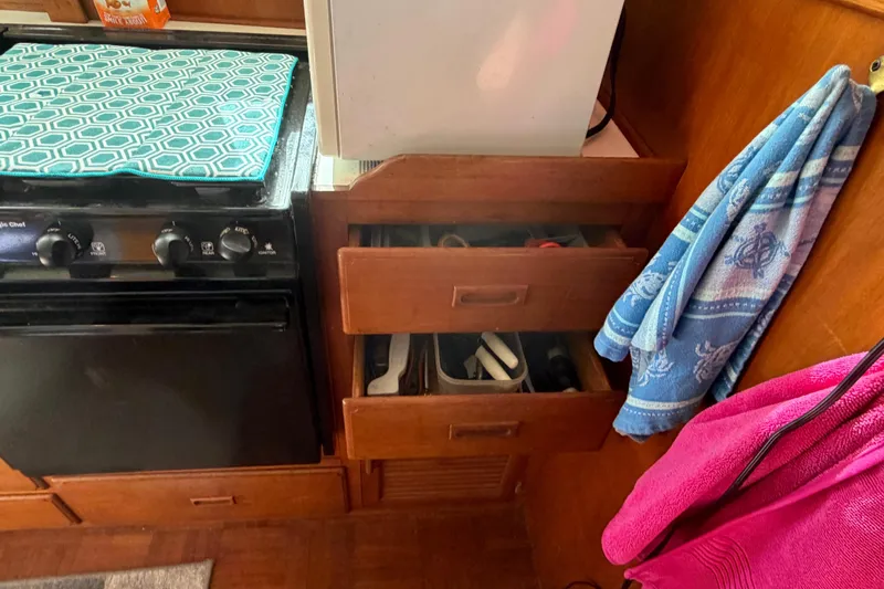 Slide: The Image of Kitchen area of 1985 Albin 36 Trawler with stove, drawers, and hanging towels. - 25