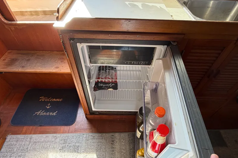 Slide: The Image of Open fridge inside 1985 Albin 36 Trawler boat, with drinks and condiments. - 27
