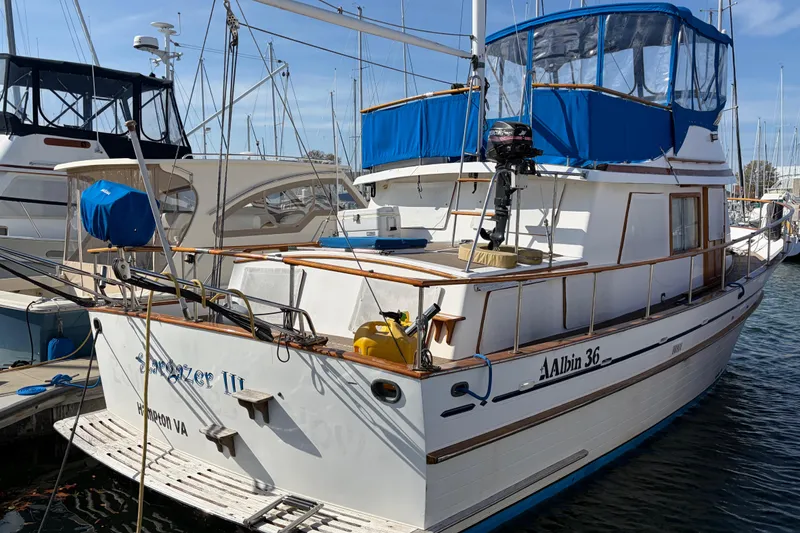 Slide: The Image of 1985 Albin 36 Trawler docked at marina with blue canopy and wooden accents. - 3