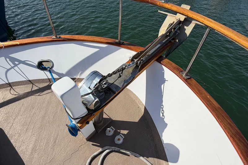 Slide: The Image of Bow of 1985 Albin 36 Trawler with anchor and winch, docked on calm water. - 5