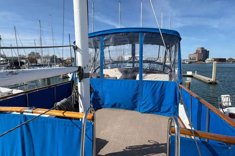 Slide: The Image of 1985 Albin 36 Trawler with blue canopy docked at marina under clear sky. - 9
