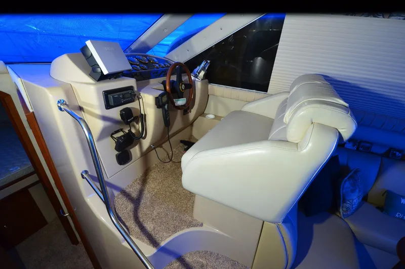 Slide: The Image of 1999 Cruisers Yachts 3585 Flybridge helm with leather seating and control panel. - 10