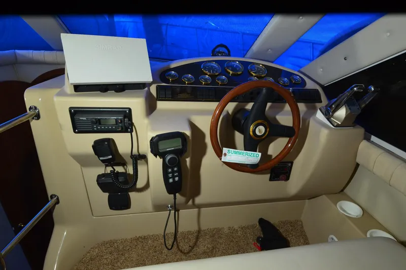 Slide: The Image of 1999 Cruisers Yachts 3585 Flybridge helm with steering wheel, gauges, and communication equipment. - 16