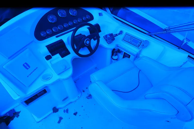 Slide: The Image of 1999 Cruisers Yachts 3585 Flybridge helm with steering wheel and control panel, illuminated in blue. - 29