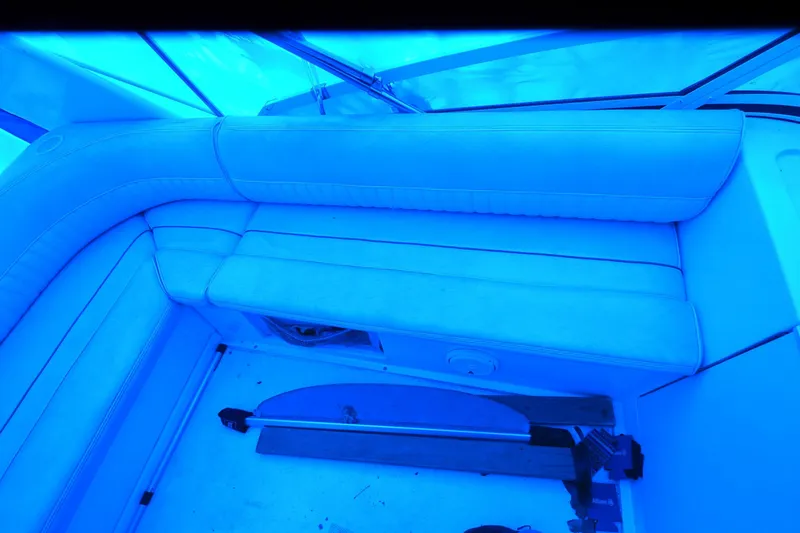 Slide: The Image of 1999 Cruisers Yachts 3585 Flybridge interior seating under blue lighting. - 30