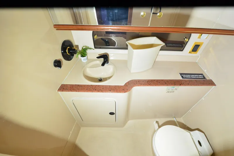 Slide: The Image of 1999 Cruisers Yachts 3585 Flybridge bathroom with sink, toilet, and mirror. - 5