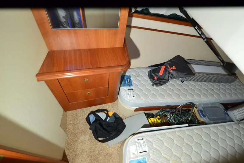 Slide: The Image of 1999 Cruisers Yachts 3585 Flybridge cabin interior with twin beds and wooden cabinet. - 7
