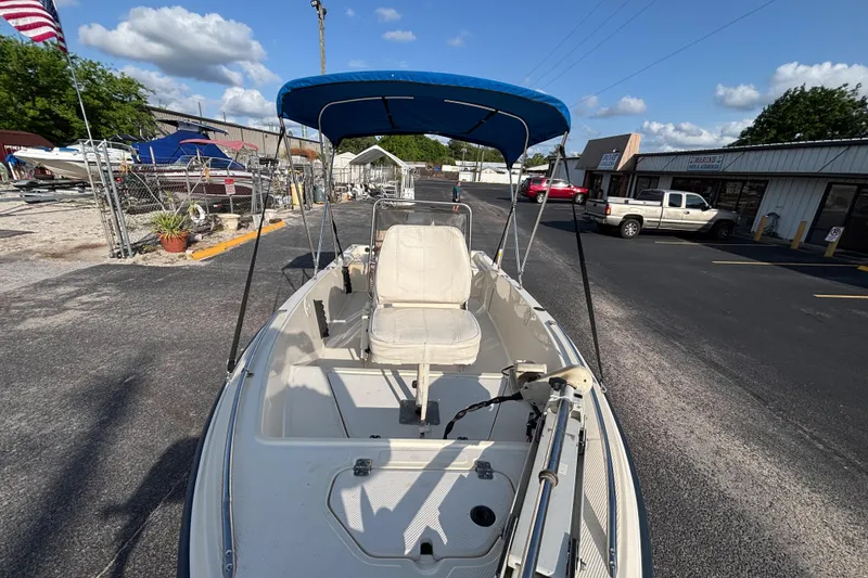 Slide: The Image of 2000 Key West 1720 Center Console boat with blue canopy in a parking lot. - 10